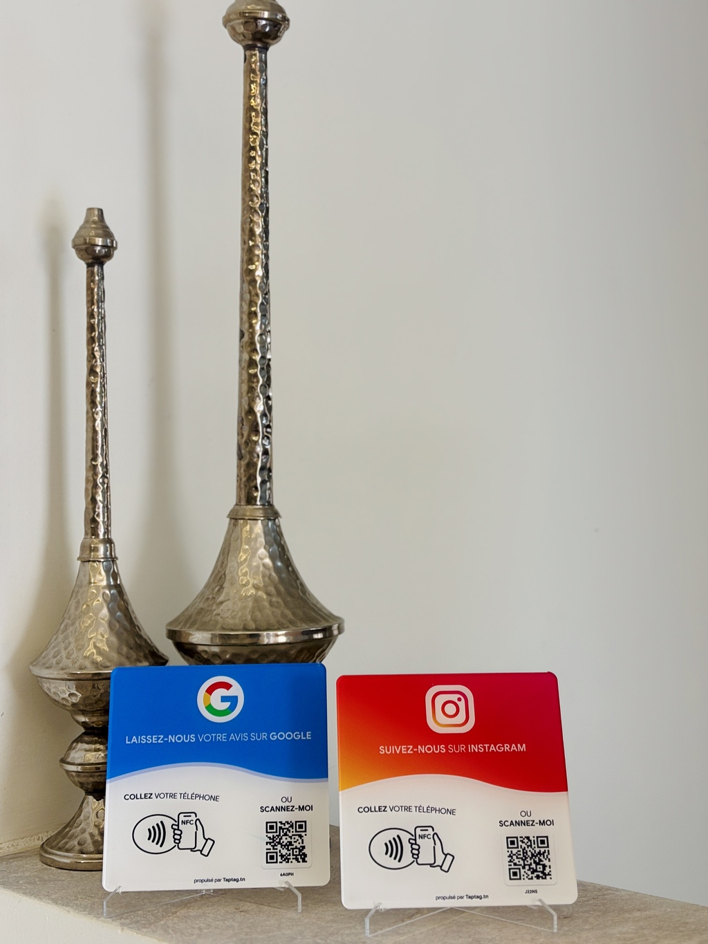 Plaques NFC TapTag Google et Instagram sur le comptoir d'un commerce